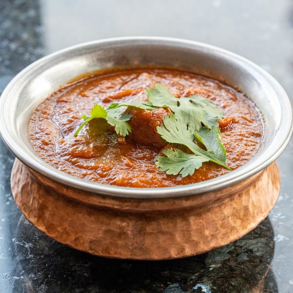Indian curry with cilantro in a copper bowl from Prabh Indian Kitchen.